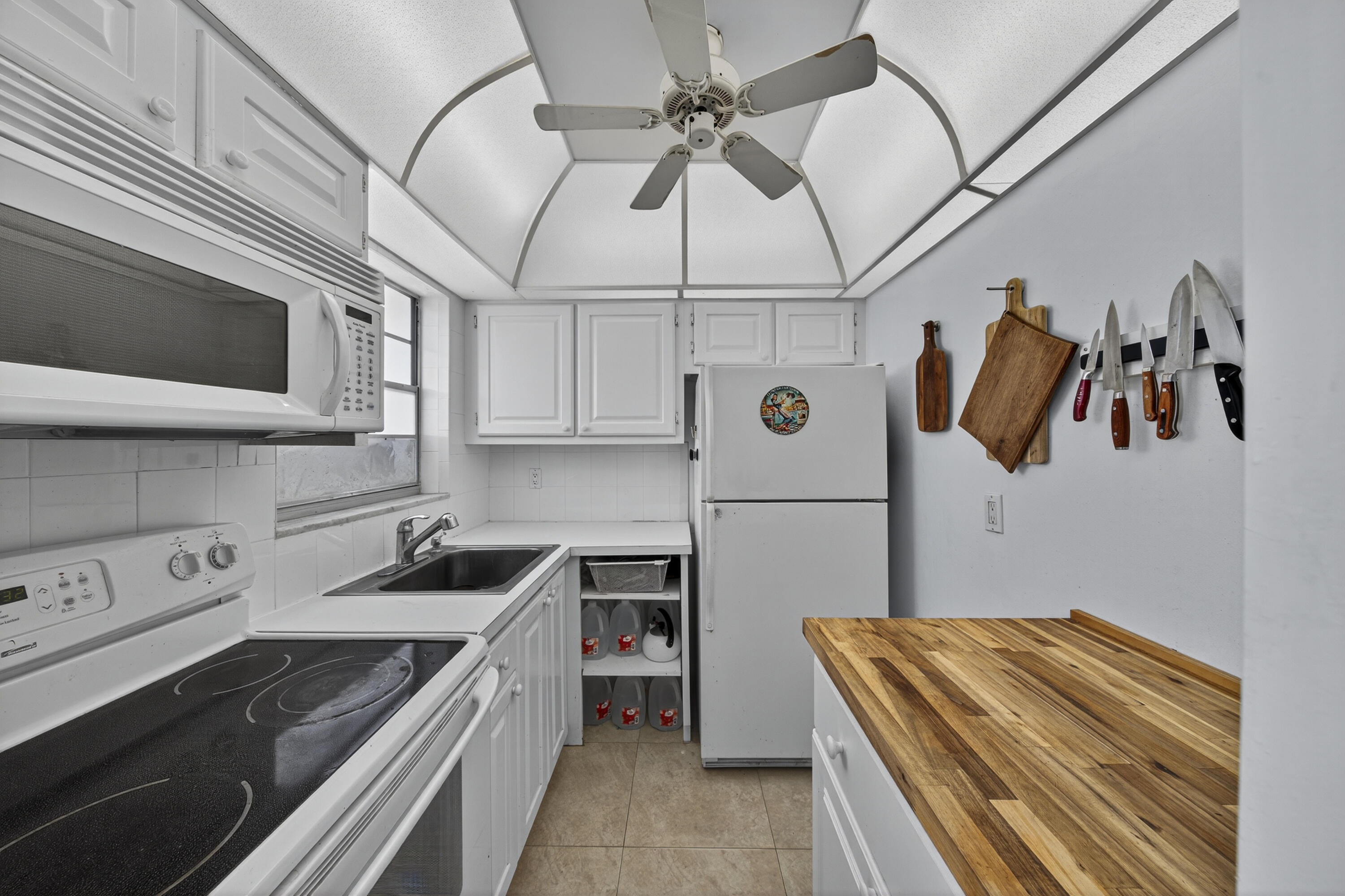 251 South Golf Boulevard, Unit 287 Pompano Beach, FL 33064 - Photo 5 of 63 a kitchen with a stove and a microwave