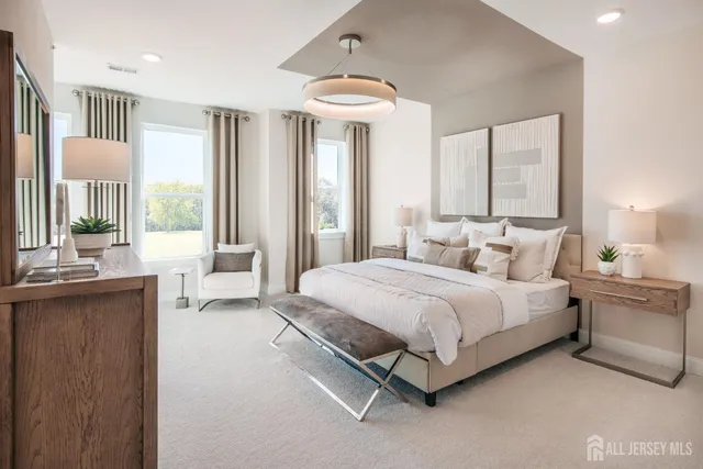 a spacious bedroom with a bed and a chandelier