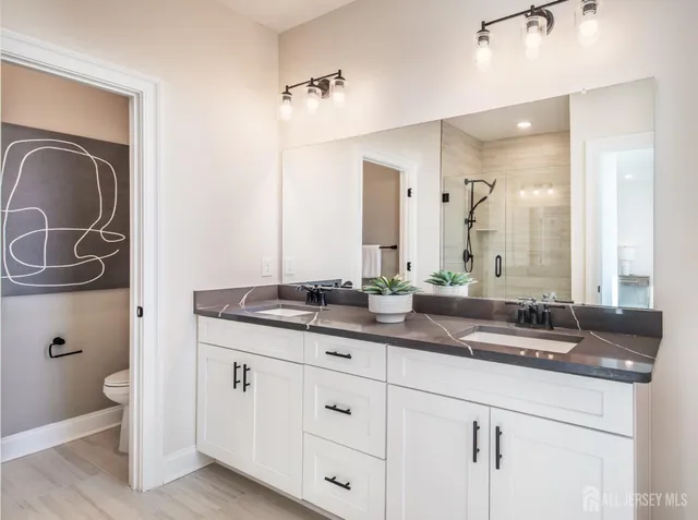 a bathroom with a granite countertop sink a toilet and a mirror