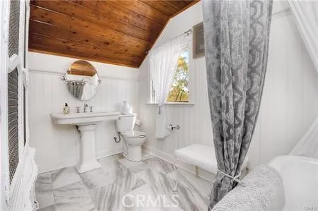 a bathroom with a sink toilet and window