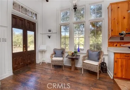 a living room with furniture large window and wooden floor