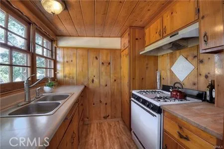 a kitchen with stainless steel appliances granite countertop a sink a stove and a wooden floors