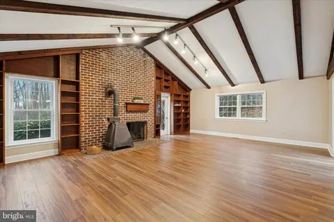 an empty room with wooden floor and fireplace