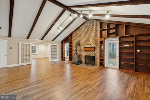 a view of a living room with wooden floors and stairs