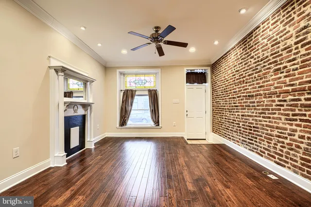 a view of empty room with wooden floor and fireplace