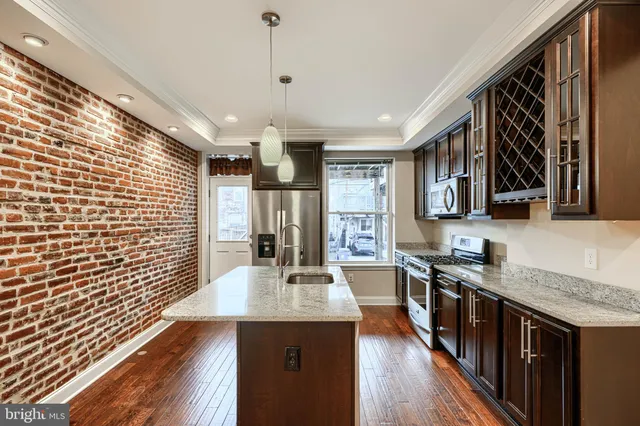 a kitchen with stainless steel appliances granite countertop a sink stove and wooden floor