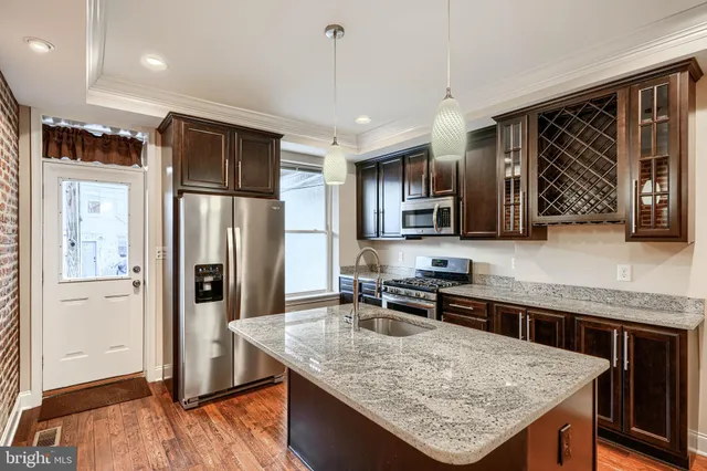 a kitchen with stainless steel appliances granite countertop a refrigerator a sink a stove and island