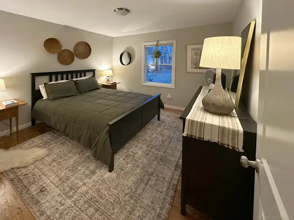 a bedroom with a bed and lamp with chair