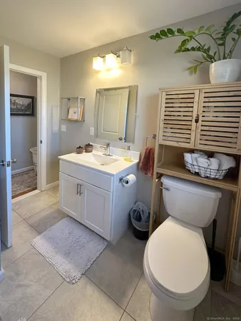 a bathroom with a toilet sink and mirror