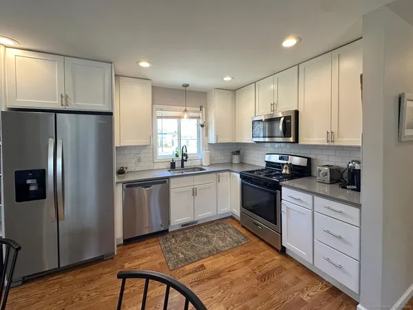 a kitchen with stainless steel appliances granite countertop a refrigerator sink and stove