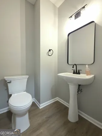 a bathroom with a toilet sink and mirror