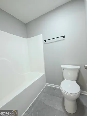 a white toilet sitting next to a bath tub