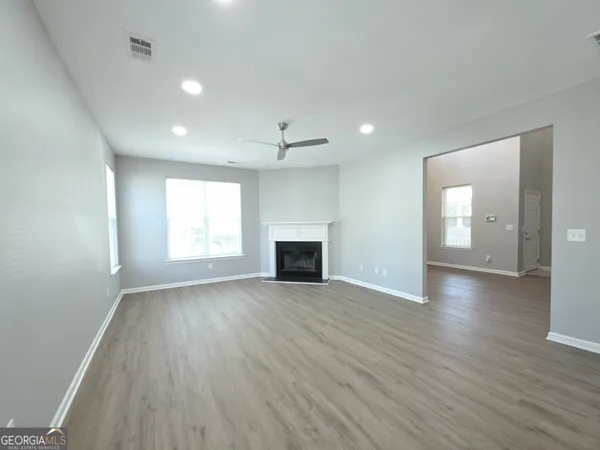 an empty room with wooden floor and fireplace
