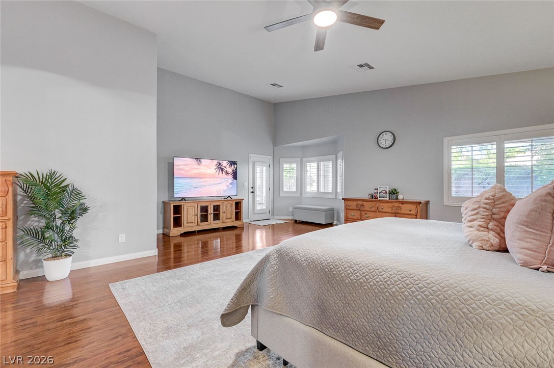 1604 Cattle Ranch Place Henderson, NV 89002 - Photo 32 of 99 Sun-filled primary bedroom features high ceilings and polished hardwood flooring.