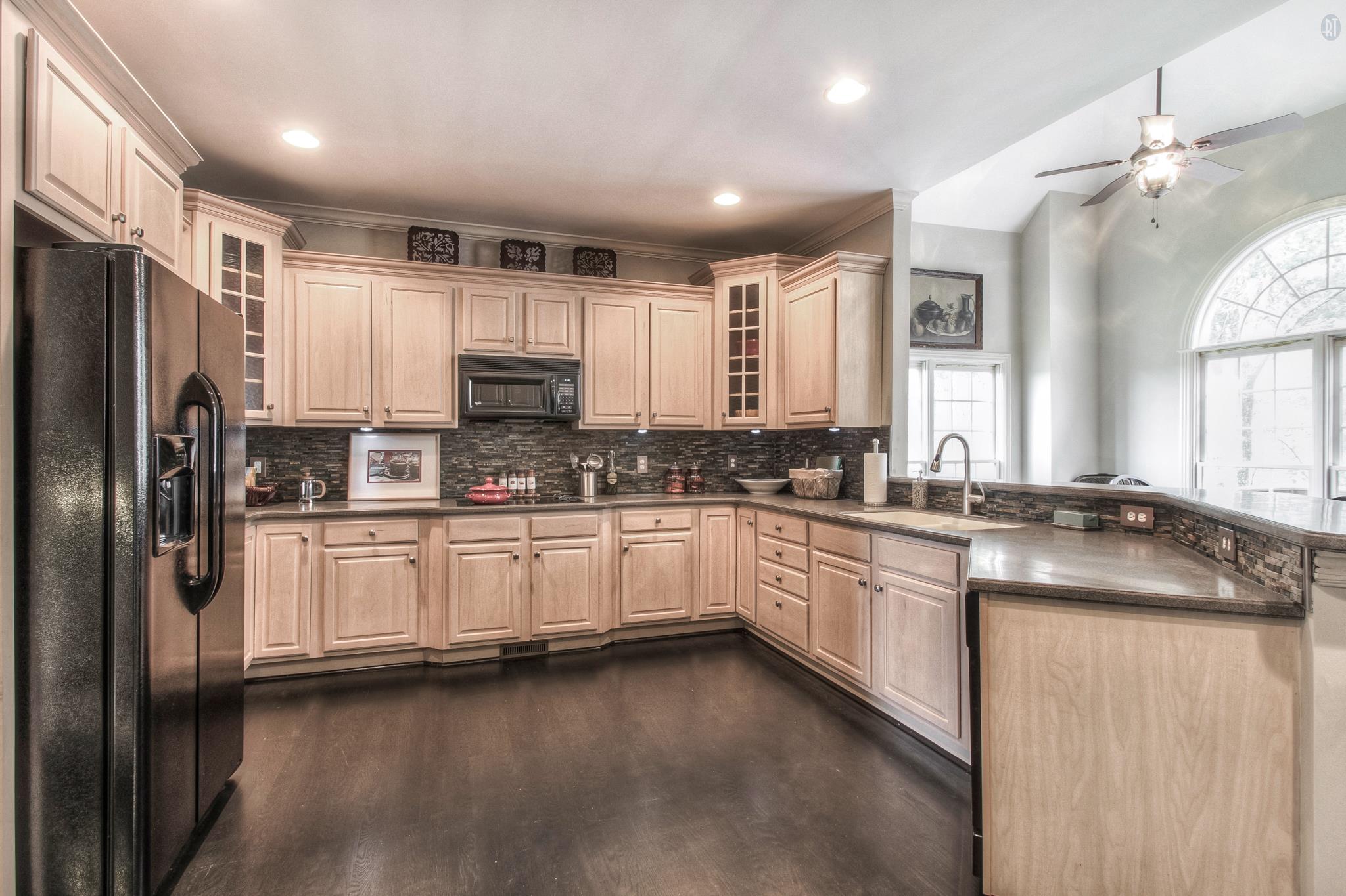 228 Halberton Drive Franklin, TN 37069 - Photo 10 of 23 a kitchen with stainless steel appliances granite countertop a refrigerator a sink dishwasher a stove and white cabinets with wooden floor