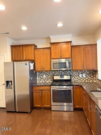 a kitchen with stainless steel appliances granite countertop a stove a refrigerator and a stove