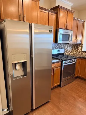 a kitchen with stainless steel appliances granite countertop a refrigerator and a stove