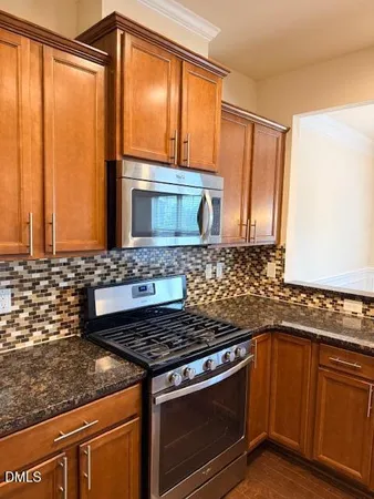 a kitchen with granite countertop a sink stove and cabinets