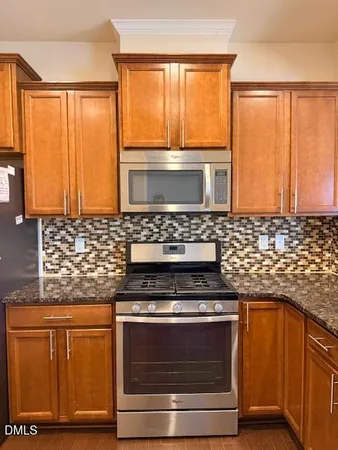 a kitchen with granite countertop wooden cabinets and a stove top oven