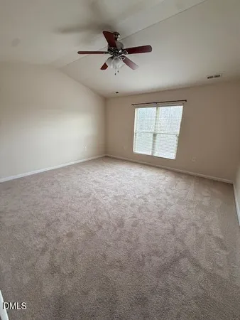 an empty room with windows and ceiling fan