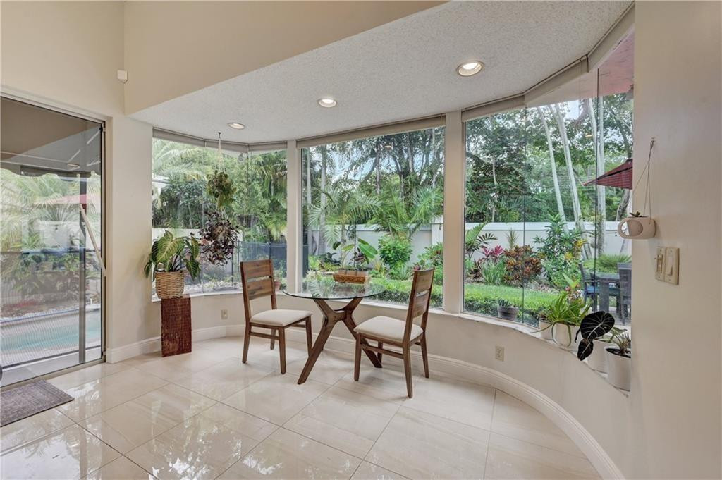 8171 Hampton Wood Drive Boca Raton, FL 33433 - Photo 10 of 56 a dining room with furniture and a garden