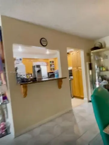 a view of a refrigerator and a kitchen with furniture