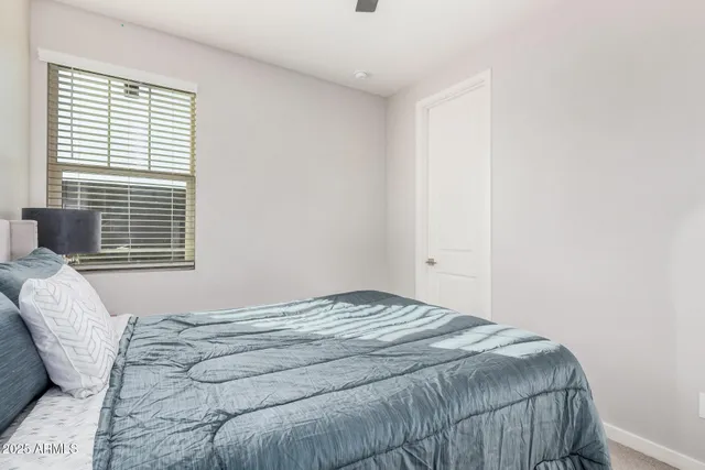 a bedroom with a bed and a flat tv screen on the dresser