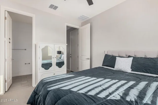 a spacious bedroom with a bed couches and window