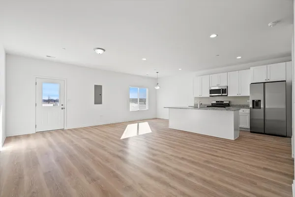 a view of kitchen view wooden floor and stainless steel appliances