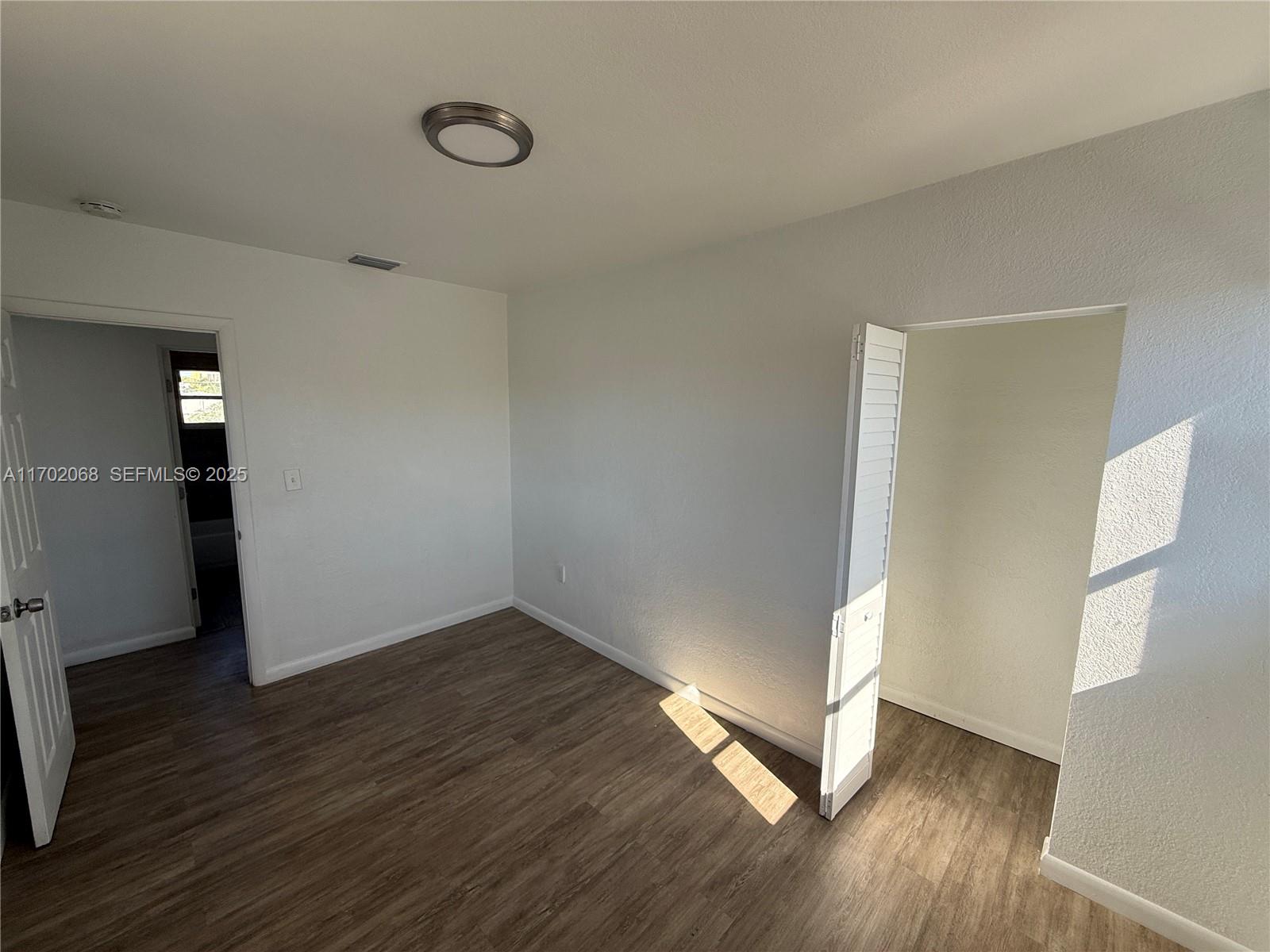 236 Southwest 10th Avenue Miami, FL 33130 - Photo 14 of 15 an empty room with wooden floor and windows