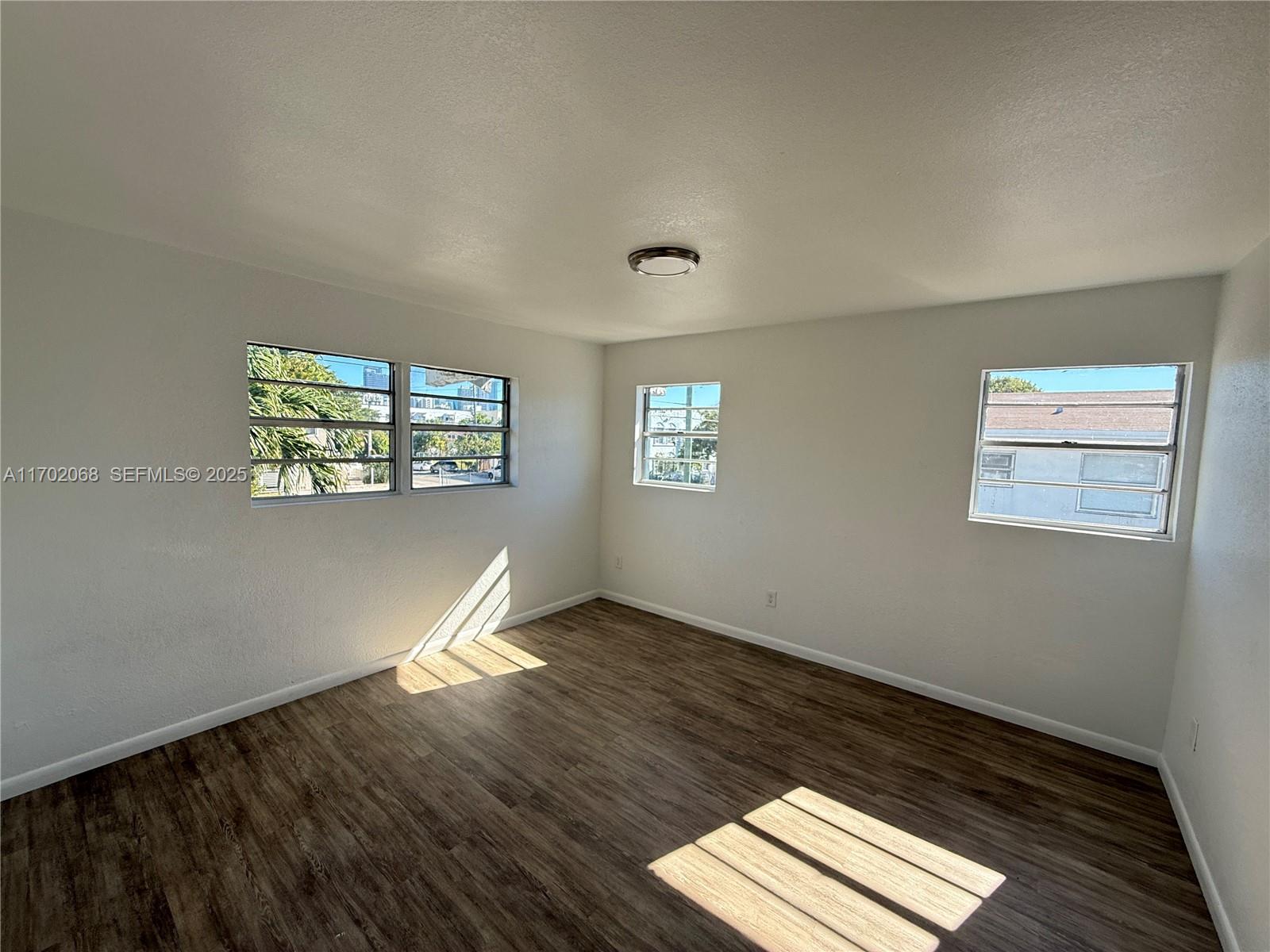236 Southwest 10th Avenue Miami, FL 33130 - Photo 7 of 15 a view of an empty room with wooden floor and a window