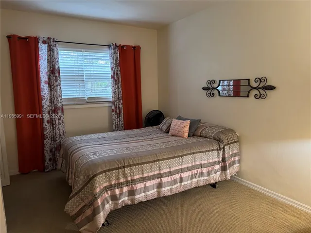 a bed sitting in a bedroom next to a window