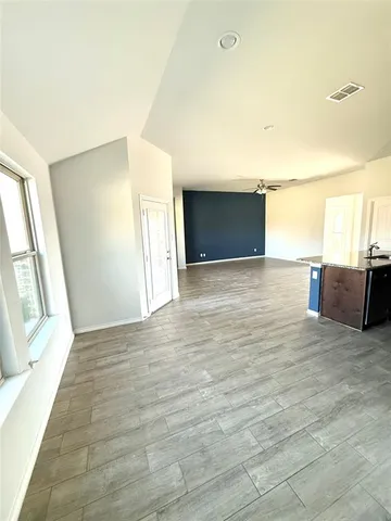 a view of an empty room with a fireplace and a window