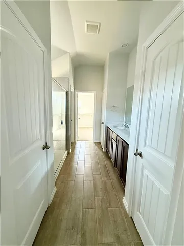 a view of a hallway with wooden floor and staircase