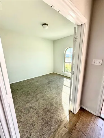 an empty room with wooden floor and a window