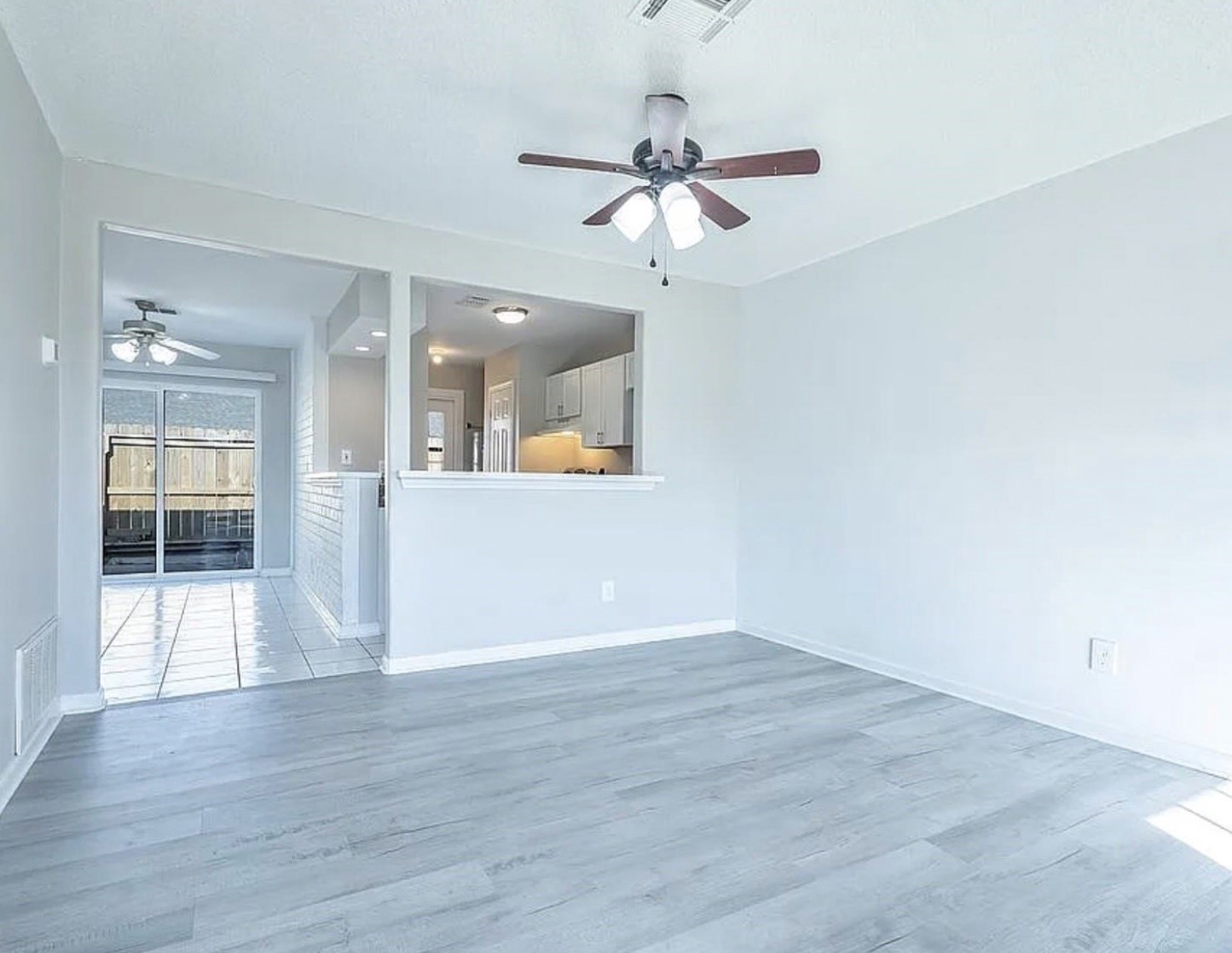 1965 Campbell Road, Unit 1965 Houston, TX 77080 - Photo 4 of 13 an empty room with wooden floor and a chandelier fan