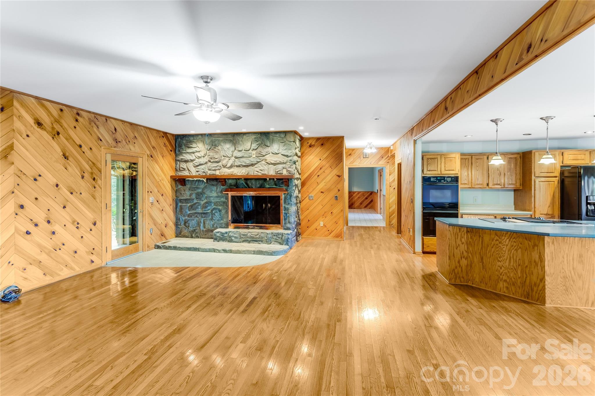 1087 Brigadoon Drive Clyde, NC 28721 - Photo 10 of 42 a view of open kitchen with wooden floor and a fireplace