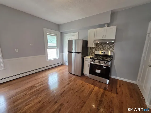 a kitchen with wooden floors and appliances