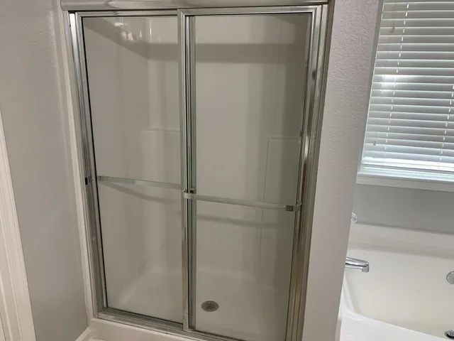a bathroom with a glass shower door