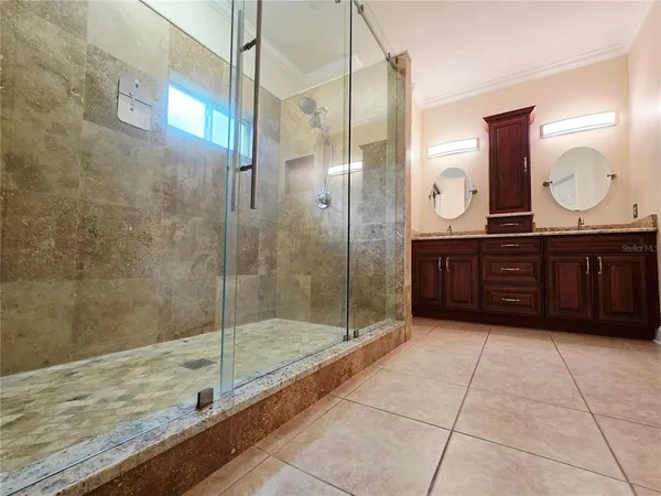 a bathroom with a granite countertop sink a mirror and shower