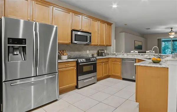 a kitchen with stainless steel appliances a refrigerator stove microwave and sink