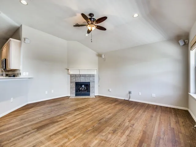 an empty room with ceiling fan and window