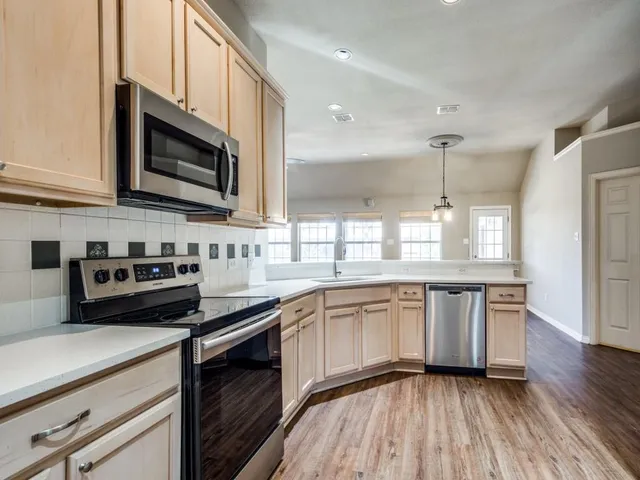 a kitchen with stainless steel appliances granite countertop a stove a sink and a microwave