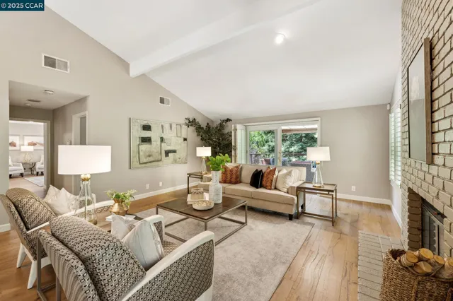 a living room with furniture fireplace and a large window