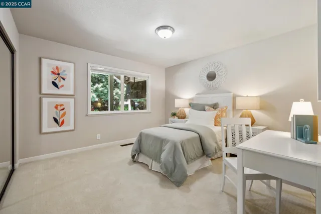 a bedroom with a bed and painting on the wall