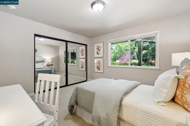 a bedroom with a bed and a large window