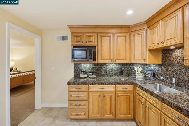 a kitchen with granite countertop a sink and cabinets