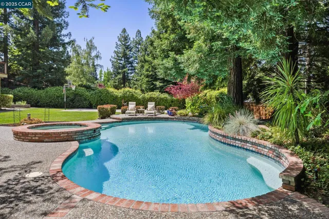 a view of a swimming pool with a yard and sitting area