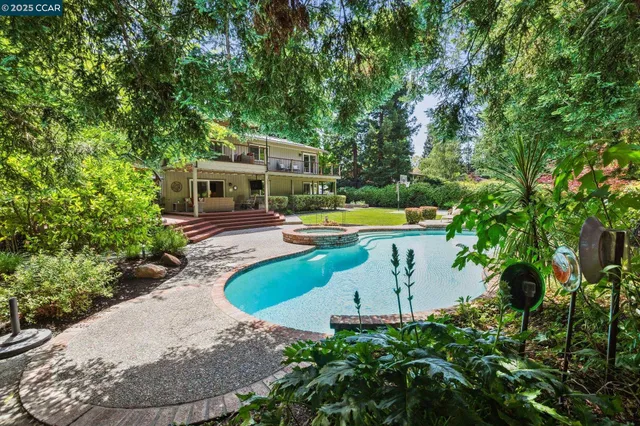 an aerial view of a house with swimming pool garden and patio