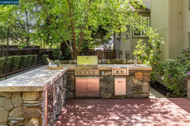 a patio with water fountain and large trees